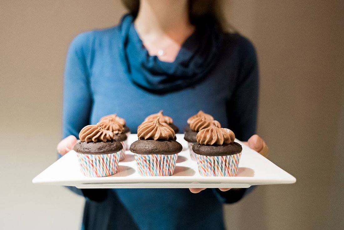 Amelie hold tray of Chocolate Cupcakes.