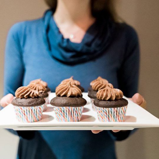 Amelie hold tray of Chocolate Cupcakes.